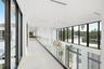 Hallway featuring floor-to-ceiling black-framed windows, frameless glass railings, recessed lighting, and integrated globe-style pendant fixtures