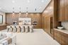 Full-height wood cabinetry featuring integrated appliances, large stone-topped kitchen island, built-in wine refrigeration, stone backsplash, and rece
