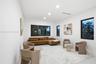 Bright interior space featuring recessed ceiling lighting, large-format smooth flooring, and expansive windows framed in dark metal