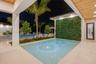 Covered patio with natural wood-finish ceiling, stone paver flooring, built-in living wall, and integrated pool