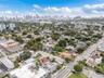 Aerial perspective of the property location featuring mature tree canopy, established neighborhood grid, and expansive city skyline background