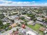 Aerial view of property situated on a corner lot featuring a multi-pitched roofline and exterior paved surface area