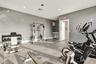 Fitness room featuring rubberized flooring, recessed lighting, and a built-in cabinetry unit with a countertop
