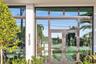 Entrance featuring a double-glass door entry, expansive floor-to-ceiling windows, dark-finished metal framing, and clerestory window accents