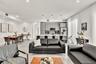 Open-concept living space featuring high-gloss cabinetry, a central kitchen island, recessed lighting, and large-format tile flooring