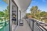 Covered balcony featuring a concrete floor, minimalist black metal railing, and floor-to-ceiling sliding glass doors
