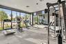 Fitness center featuring floor-to-ceiling windows, full-wall mirrors, recessed lighting, and rubberized modular flooring