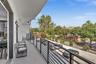 Covered balcony featuring a concrete surface, black metal railing, and retractable glass doors