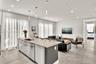 Kitchen island featuring stone countertops, stainless steel undermount sink, and integrated stainless steel dishwasher, complemented by recessed light