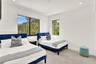 Neutral-toned tile flooring, recessed ceiling lighting, and large-format dual windows with exterior foliage
