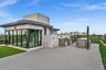 Rooftop terrace featuring concrete flooring, a built-in outdoor kitchen with a stainless steel grill, a stone-finish bar, and a glass-enclosed structu