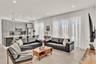 Open-concept interior featuring high-gloss cabinetry, stone-surface kitchen countertops, large-format tile flooring, and floor-to-ceiling windows with