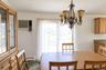 Dining area featuring a decorative wrought-iron chandelier, built-in wooden cabinetry, and sliding glass doors
