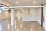 Open-concept interior space  concrete flooring, recessed lighting, and structural support columns