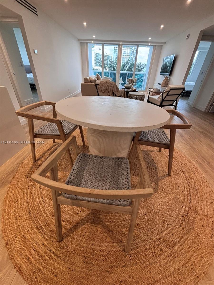 Open-concept area featuring wood-finish flooring, recessed lighting, and floor-to-ceiling windows