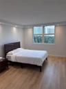 Wood-finish flooring, recessed ceiling lighting, and large windows with exterior urban scenery