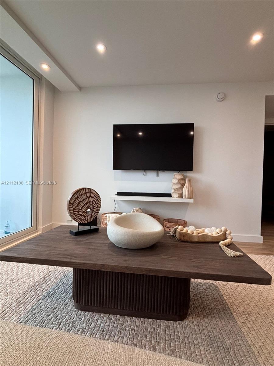 Full-height glass panel, recessed ceiling lighting, and wall-mounted floating display shelf