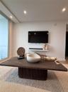 Full-height glass panel, recessed ceiling lighting, and wall-mounted floating display shelf