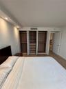 Built-in wardrobe system with wood-finish shelving and cabinetry, recessed ceiling lighting, and light-toned wood-finish flooring
