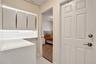 Built-in cabinetry with integrated under-cabinet lighting, solid-surface countertop, and six-panel interior door with brushed metal hardware