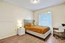 Room featuring wood-finish flooring, textured ceiling with flush-mount lighting, and a window equipped with horizontal zebra-style blinds