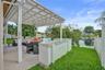 Covered patio featuring a white pergola, built-in concrete bar, concrete flooring, and water frontage
