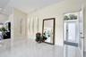Entryway featuring large-format tile flooring, high vaulted ceilings, triple recessed wall niches, and a glass-paneled entry door with an arched trans