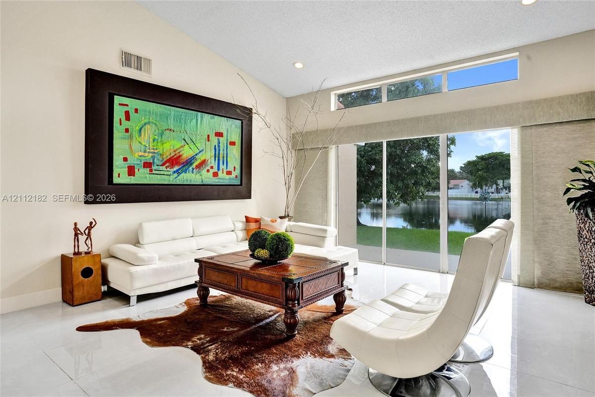 Vaulted ceilings, expansive glass sliding doors, high-placed clerestory windows, and polished tile flooring