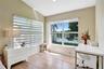 Vaulted ceiling with wood-finish flooring, dual-aspect windows, and water-facing exterior exposure