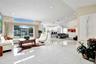 Open-concept interior featuring polished porcelain tile flooring, high vaulted ceilings, recessed lighting, expansive glass sliding doors, and transom