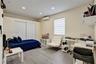 Room featuring wood-finish flooring, recessed lighting, sliding closet doors, a wall-mounted ductless air conditioning unit, and a window with horizon
