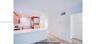 Kitchen featuring wood-finish cabinetry, white countertop, white subway tile backsplash, and wood-finish flooring