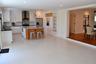 Kitchen featuring white shaker cabinetry, an island with a wood-finish base and stone countertop, geometric tile backsplash, stainless steel appliance