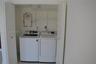 Laundry closet featuring white bifold doors, installed white washer and dryer, and wire shelving