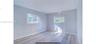 Room with neutral-toned walls, wood-finish tile flooring, and two sliding windows