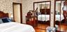 Wood-finish flooring, dual floor-to-ceiling mirrored closet doors, and wood-trim door casing