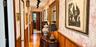 Hallway featuring patterned wallpaper, horizontal wood wainscoting, wood-finish flooring, and adjustable track lighting