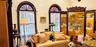 Textured walls, vaulted ceiling, and dual arched windows featuring dark-toned wood trim and semi-circular transom panes