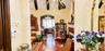 Arched entryways featuring textured walls, dark wood-finish ceiling beams, and hardwood flooring