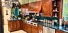 Kitchen featuring custom wood cabinetry, a decorative wood range hood, integrated stainless steel appliances, a multi-burner gas cooktop, and polished