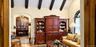 Vaulted ceiling featuring dark-stained exposed beams, arched entryway, and arched window with decorative molding