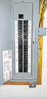 Electrical service panel featuring multiple circuit breakers, labeled directory, and wall-mounted exterior light switch
