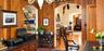 Wood-paneled walls, arched entryways, built-in shelving, fireplace with decorative tile surround, and hardwood flooring