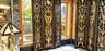 Natural stone wall surfacing with polished finish, expansive windows with wood-trim framing, and built-in stone vanity