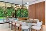 Floor-to-ceiling glass walls, wood-finish wall paneling, modern multi-arm chandelier, wood-finish ceiling, and light-toned wood-finish flooring