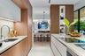 Modern kitchen featuring flat-panel wood cabinetry, quartz countertops, a high-arc chrome faucet, integrated shelving, and a smooth cooktop