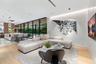 Open-concept floor plan featuring expansive floor-to-ceiling glass panel walls, wood-finish flooring, recessed lighting, and a modern kitchen island w