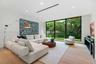 Floor-to-ceiling black-framed windows, wood-finish flooring, recessed lighting, and linear HVAC diffuser