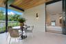 Covered balcony featuring wood-paneled ceiling, stone-finish wall cladding, large-format tile flooring, frameless glass railings, and expansive slidin