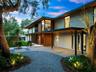 Contemporary architectural exterior featuring a combination of wood-paneled siding and smooth finish surfaces, extensive roof overhangs, custom-design